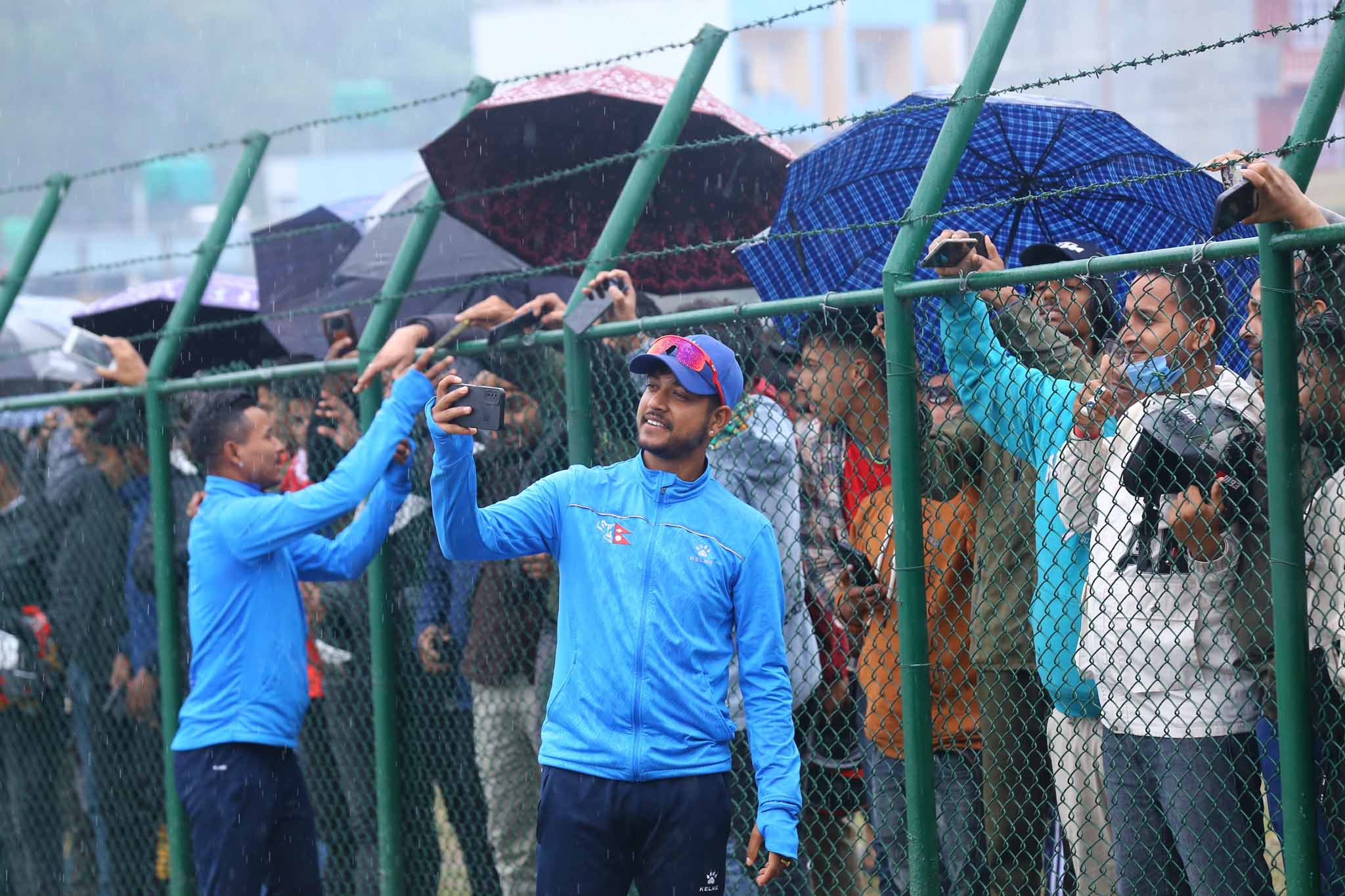 Nepali players taking selfies with cricket fans after the match called off (photos)