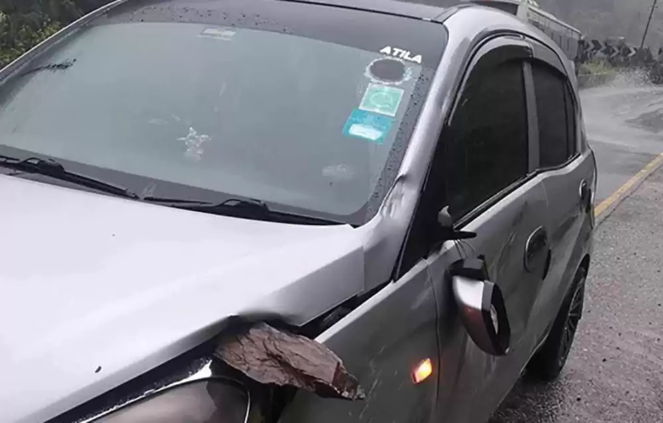 Rock falls on moving car