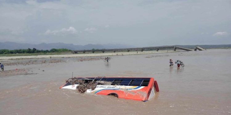 Passenger bus swept away by flooded river