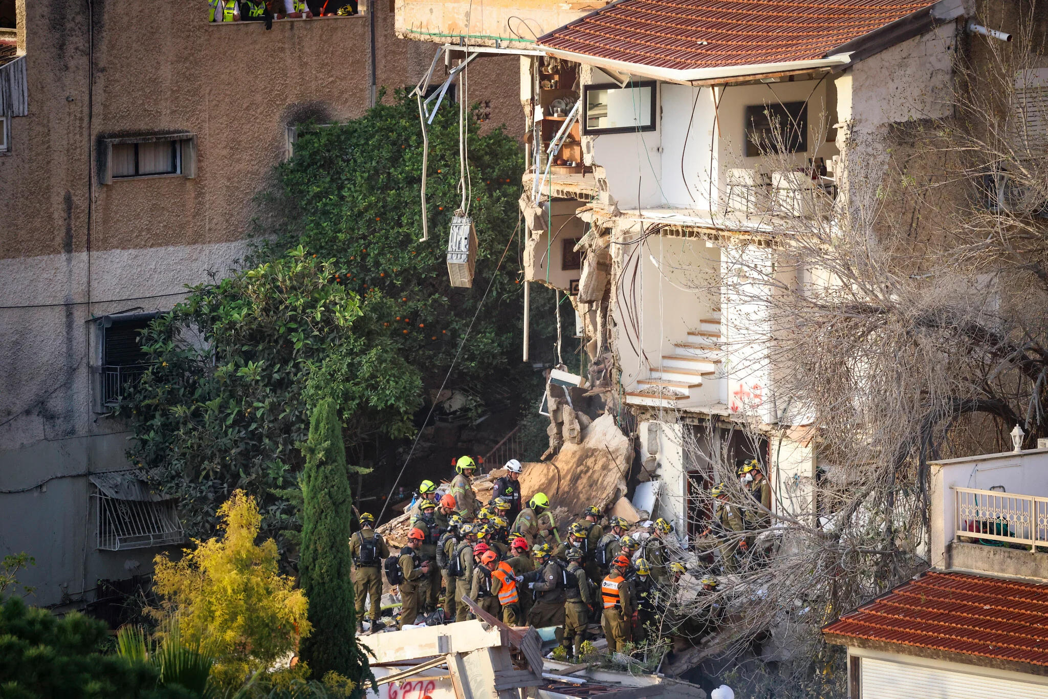 Israeli rescuers search for missing in building strike, two dead
